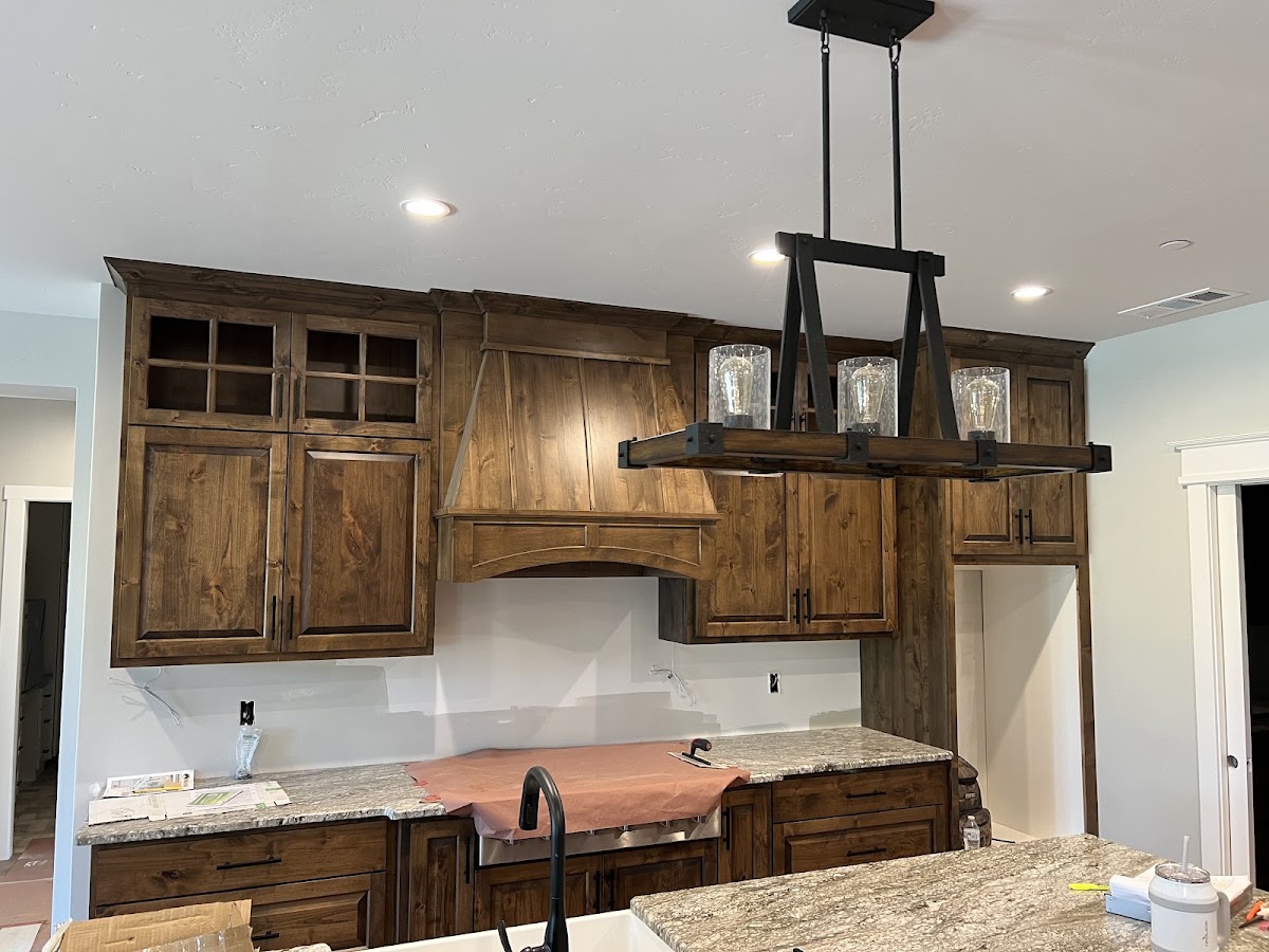 Custom wood kitchen cabinetry with a paneled range hood by Jefferson State Cabinet Company